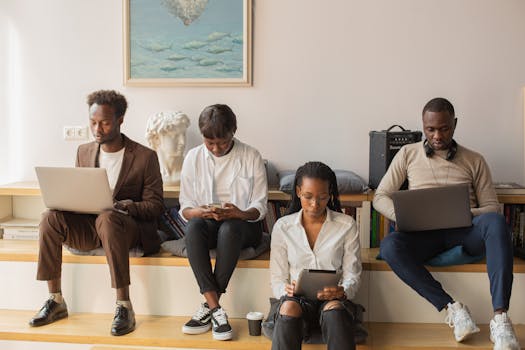 A group of diverse professionals using technology indoors, focused and engaged in a modern workspace.